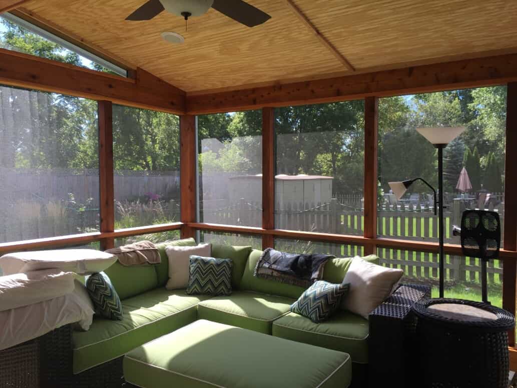 screened porch with green couches